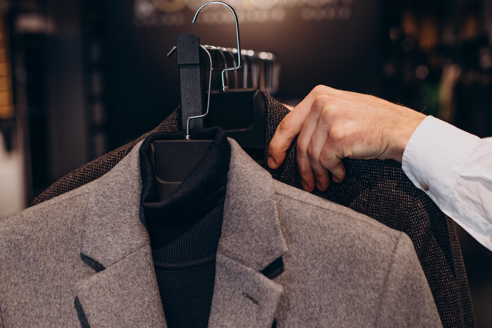 young-man-choosing-cloths-menswear-shop